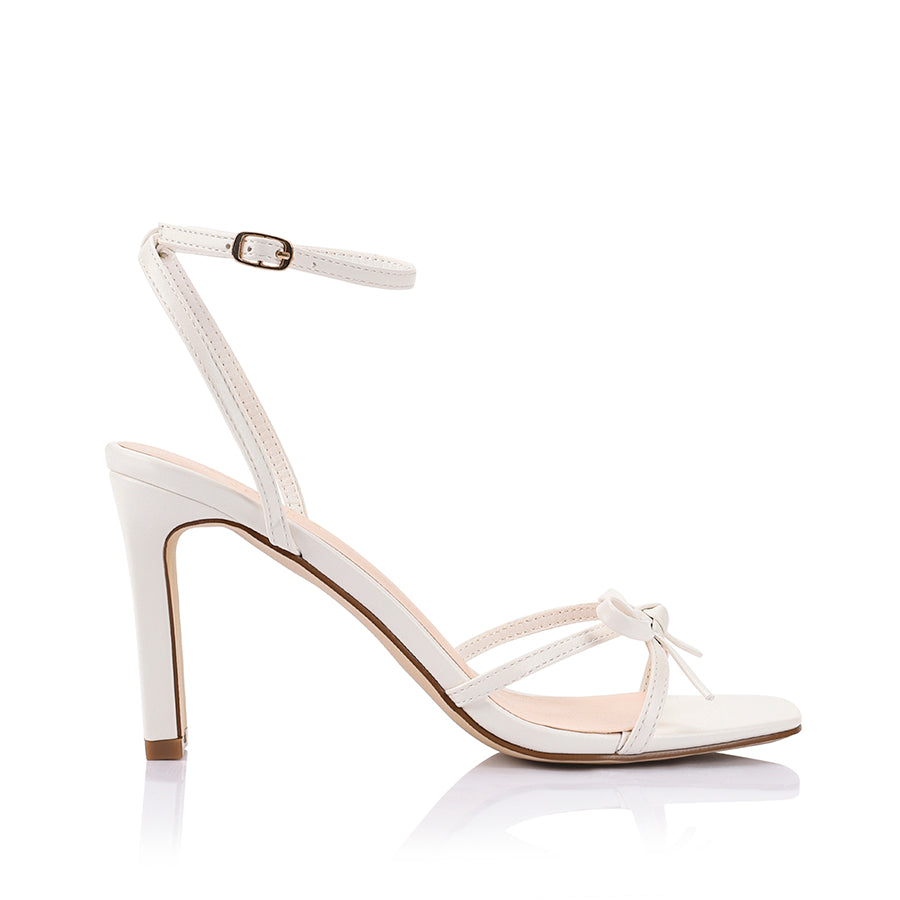 Women's chalk white vegan strappy high heels, with thin straps, bow detail and buckle up ankle strap